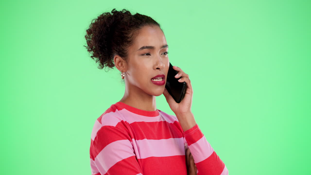 Woman talking on the phone against a green screen