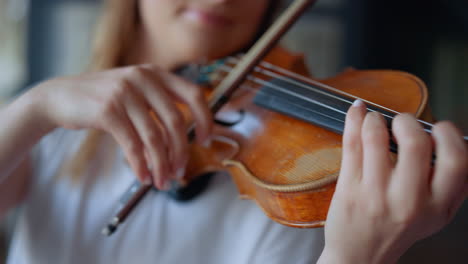 manos de mujer tocando el violín. músico presionando las cuerdas del violín con los dedos