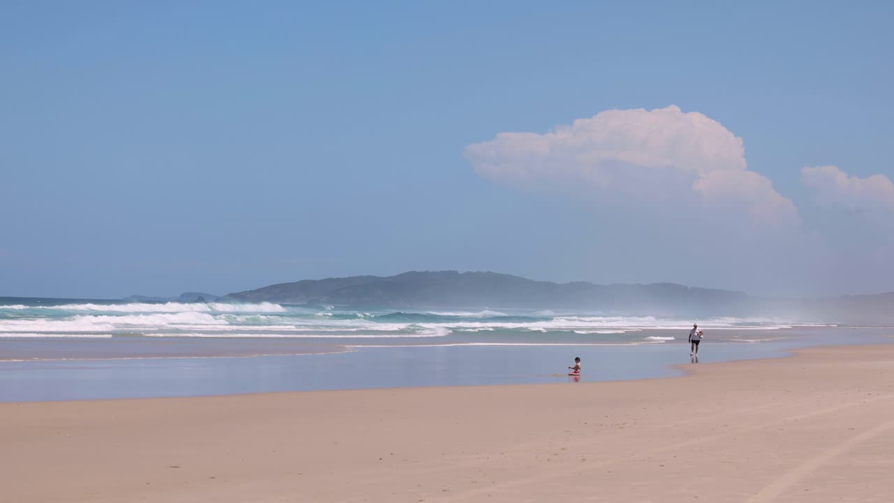 personas disfrutando de un día soleado en una playa de arena