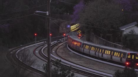 a train heads into a tunnel as night falls