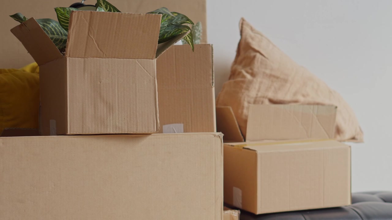 Close-up shot showing stacked cardboard boxes and home decor items ready for moving