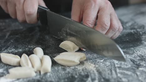 two hands making dough for meat dumplings.