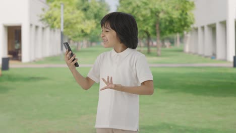 angry indian boy talking on video call in park