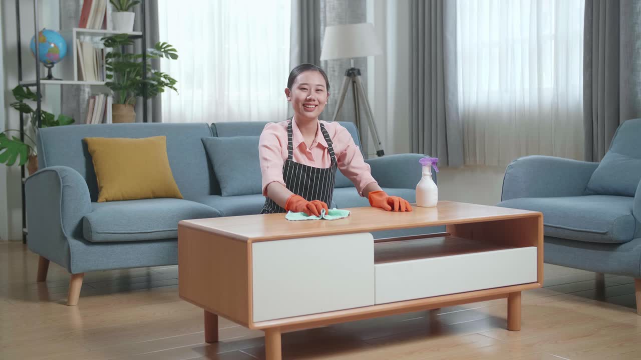 거실 에서 커피 테이블 을 청소 하는 여자