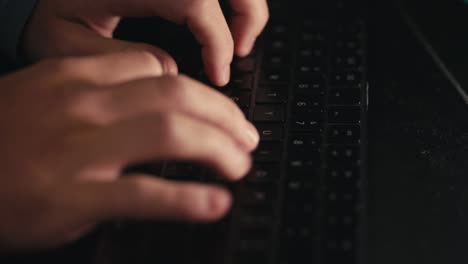 side view of fingers typing on a black keyboard