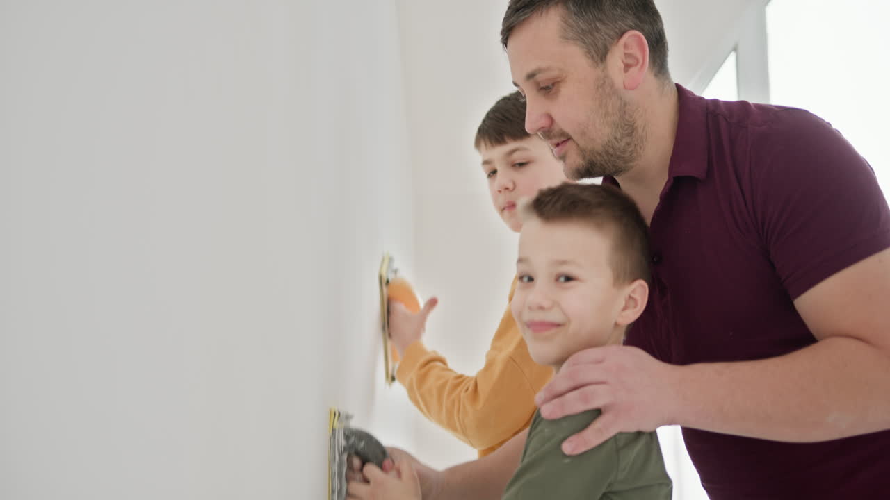 padre e hijos reparando una pared