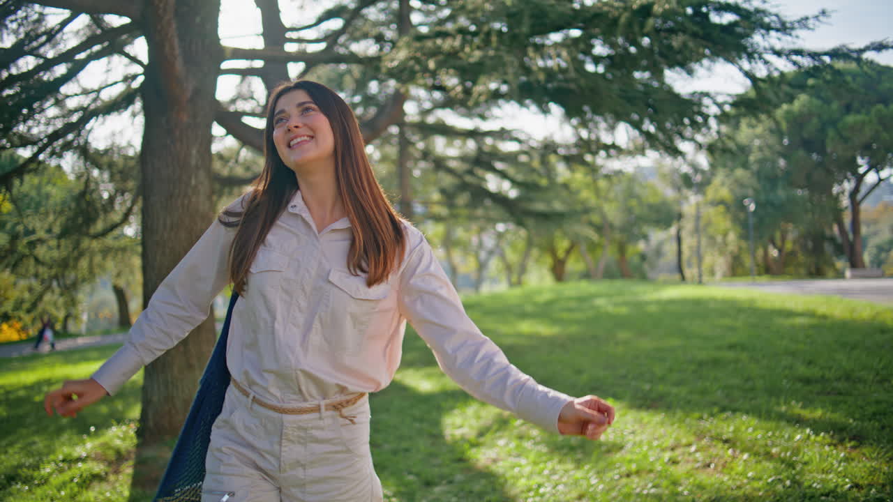 평화로운 환경에서 편안하게 산책하는 자연의 행복한 여인. 공원에서 산책하는 여성