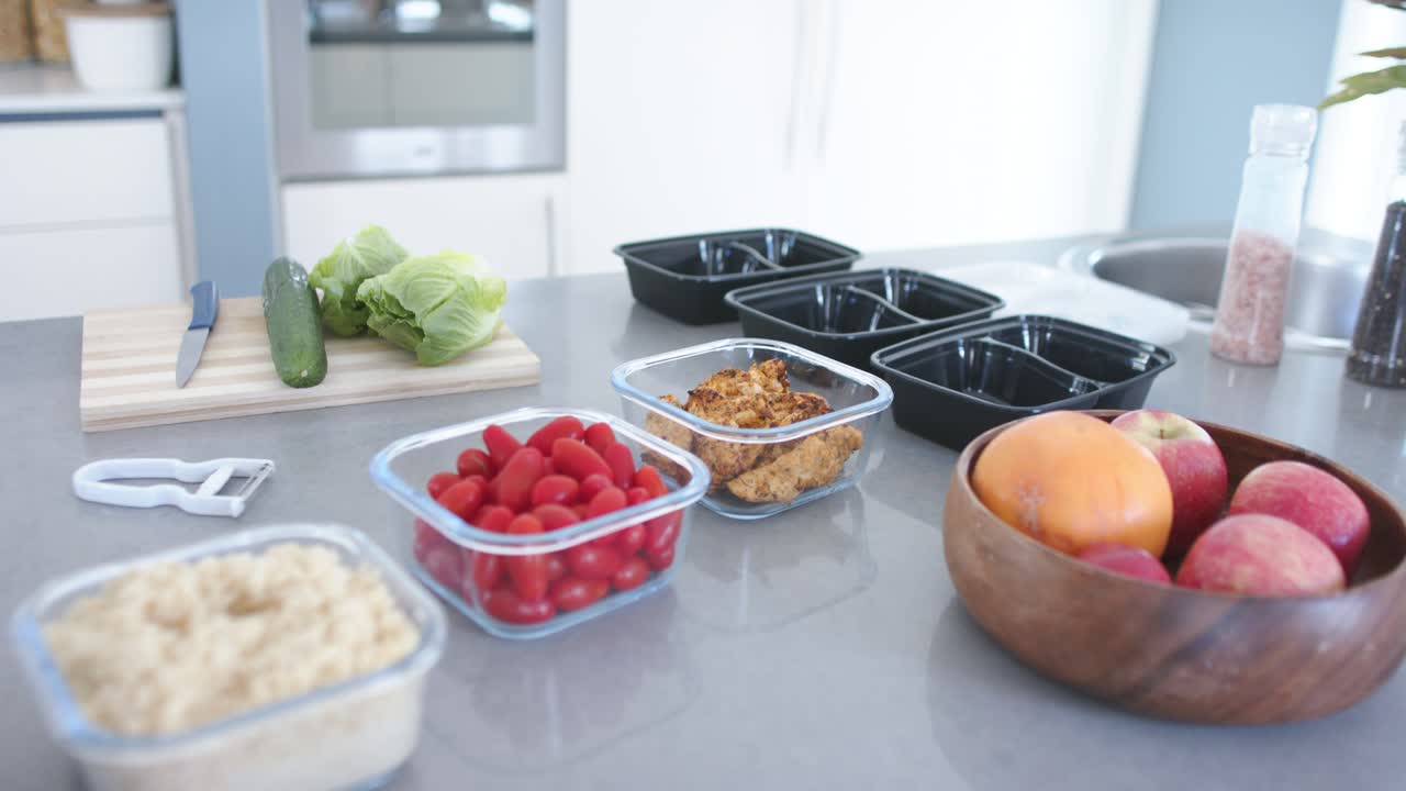 Camera moving forward, focusing on clear containers wooden fruit bowl and empty trays for packing