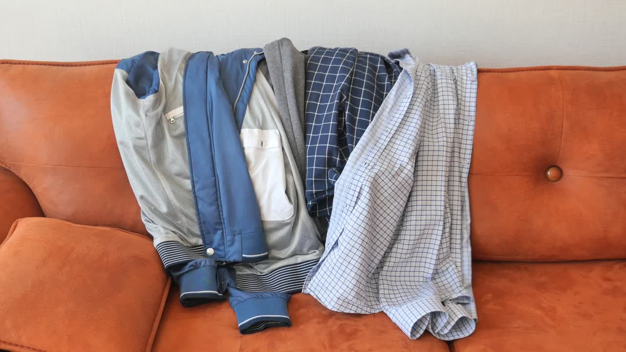 una pila de ropa en un sofá marrón