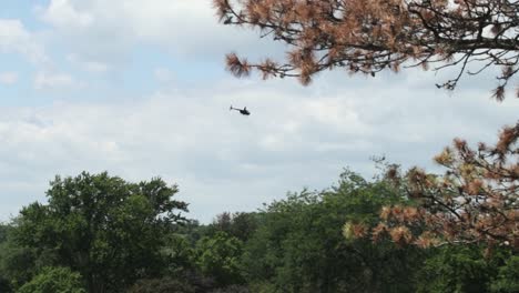 a private helicopter flying over the rural countryside on a sunny day