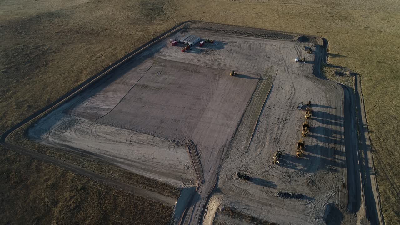 downshot de gran altitud sobre una plataforma de fracking en su mayoría vacía durante la tarde