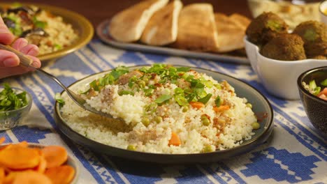 eating couscous with chicken on table close-up. arabian cuisine. pita and bulgur on background. traditional middle eastern culture. delicious rice with meat. homemade food concept