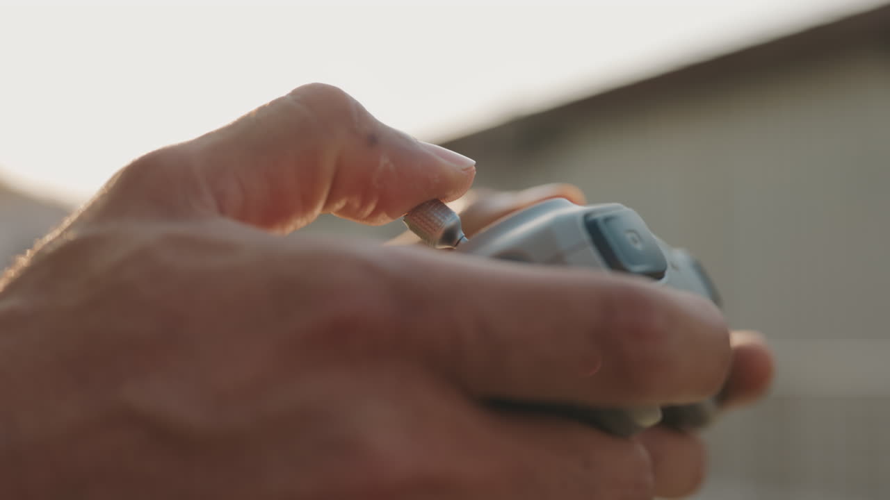 Person operating a drone controller outdoors