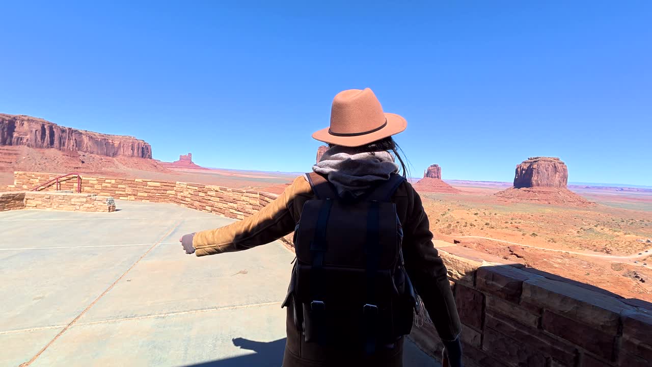 Mulher com Mochila Sai do Edifício para Ver Monument Valley