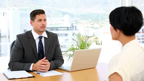 handsome businessman with laptop interviewing a businesswoman