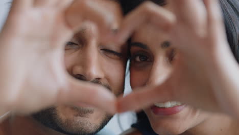 feliz pareja india haciendo forma de corazón con las manos gesticulando compromiso romántico disfrutando de la relación amorosa en el día de san valentín