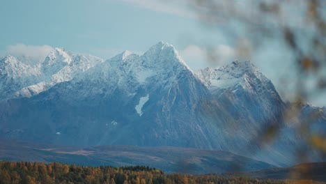 las montañas cubiertas de nieve florecen sobre el valle de otoño