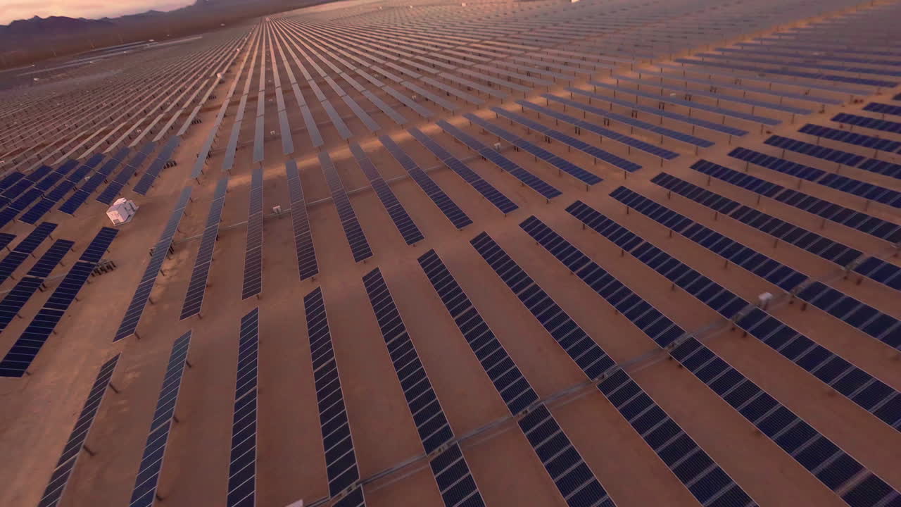 FPV-drone flyver gennem solpaneler på en ørken-solcellefarm i slowmotion