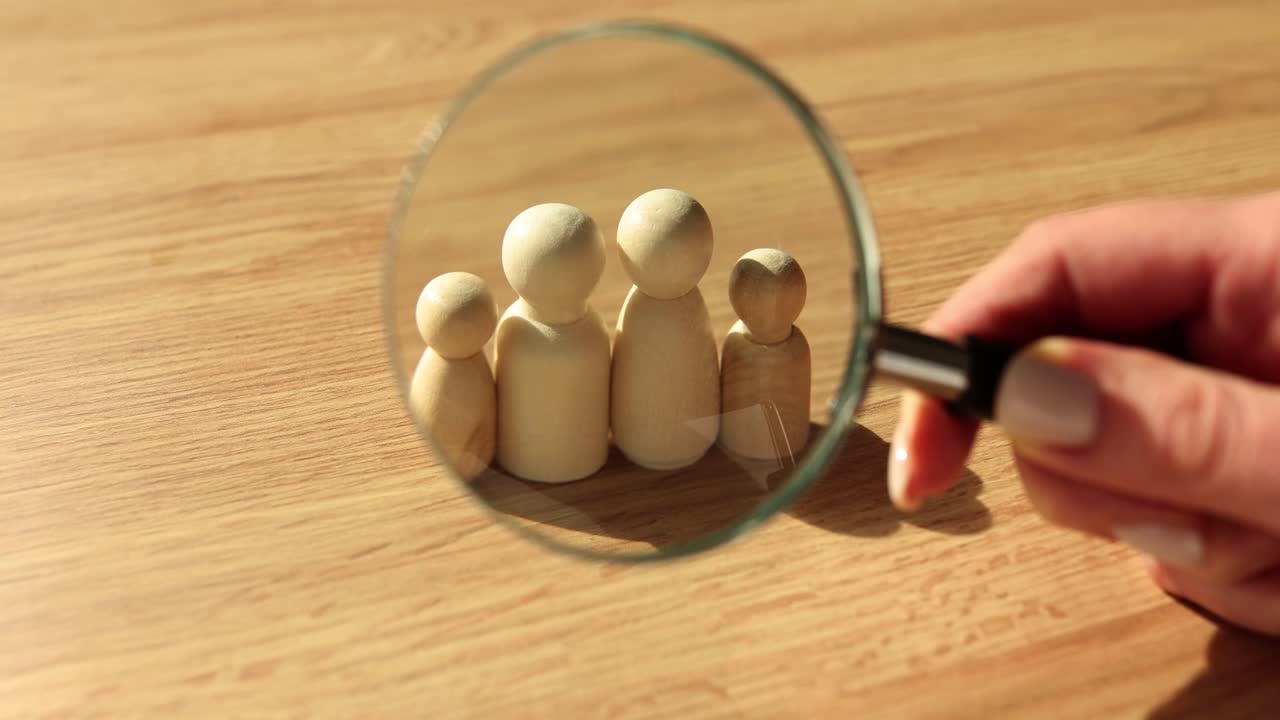 Magnifying Glass Focusing on Wooden Family Figures