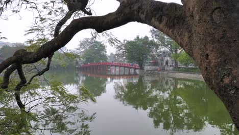 hand-held shot of hanoi’s hoan kiem lake with the iconic the huc bridge. vietnam