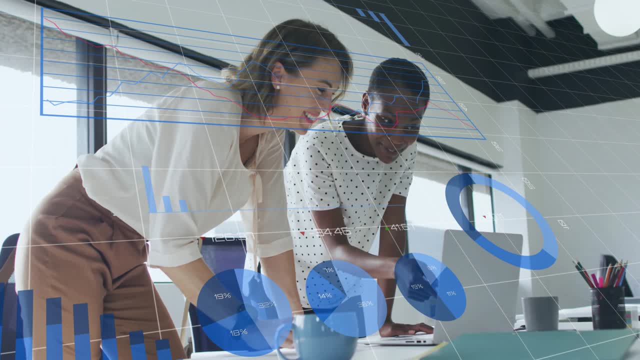 Female colleagues pointing at animated charts scrolling through business data, typing insight notes