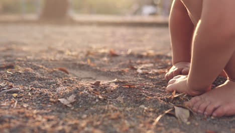 Zeitlupen-Nahaufnahme-Von-Kleinen-Kinderhänden,-Die-Im-Sandkasten-Eines-Parks-Mit-Schmutz-Greifen-Und-Damit-Spielen