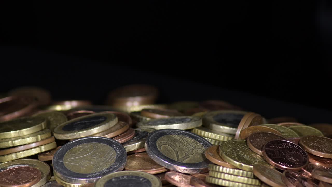 monedas de euro en una montaña de monedas que giran sobre un fondo negro
