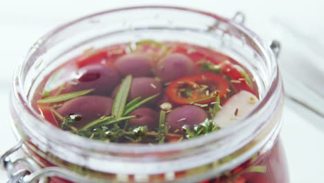 pickled olives and herbs in a jar