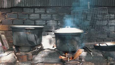 wide shot of blackened cooking pots on open flames