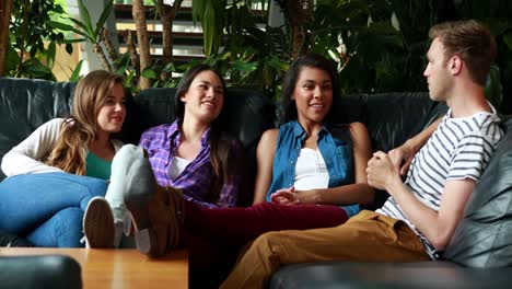 amigos felices sentados en el sofá hablando