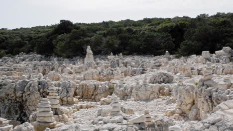 Stone-Stacks-On-The-Rocky-Alexia-Beach-In-Greece---panning-shot