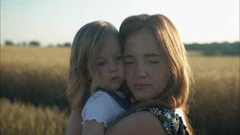 happy mother and daughter hugging together outside in summer sunset having positive, loving family or mothers day moment in cinematic slow motion