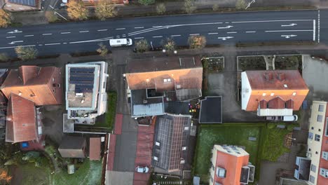 houses and garden with cars on main street. frosty autumn day in small town. red roof tiles and solar panels in historic town of usa. aerial top down flyover.