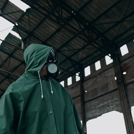 person in protective uniform and gas mask. polluted zone after chemical attack emissions. woman wearing hazmat suit on the background of destroyed building