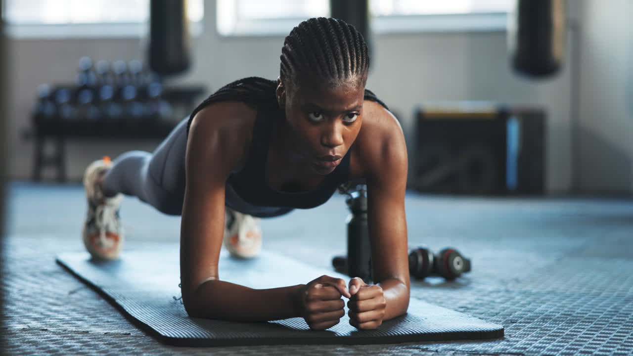Strong, plank and a black woman at the gym