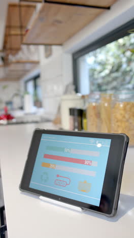 vertical video of tablet with smart home interface in kitchen, slow motion