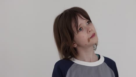 portrait of a young child with a birthmark on the cheek looking pensively