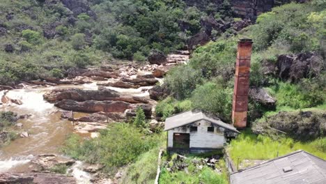 Un-Viejo-Edificio-Abandonado-Al-Lado-De-Un-Río-Rocoso-En-Colinas-áridas-1