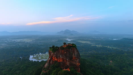 tourists walk on the top of the unusual mountain with rounded sides. landmark of sri lanka, south asia. hazy scenery at backdrop.