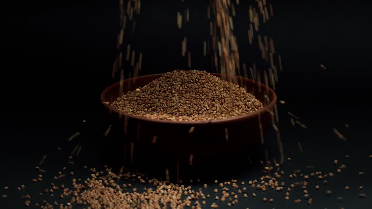 Hands Pouring Buckwheat Groats into a Bowl in Slow Motion