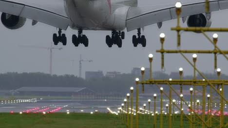 el airbus a380 de emirates aterriza bajo una fuerte lluvia.