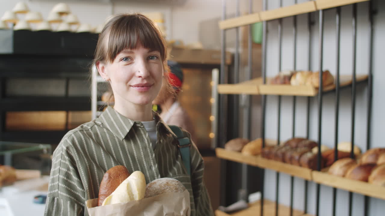retrato de una hermosa cliente femenina con pan en la panadería