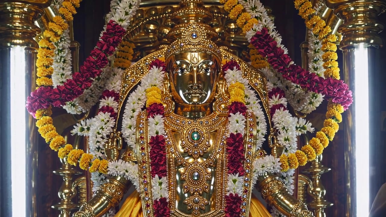 Estátua Dourada de Divindade Hindu Decorada com Guirlandas Florais em Templo