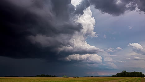 Aufnahme-Einer-Erntemaschine,-Die-Sich-An-Einem-Regnerischen-Tag-Entlang-Eines-Reifen-Weizenfeldes-Bewegt,-Während-Dunkle-Regenwolken-Vorbeiziehen