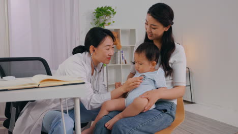 Mother and baby boy visit to the doctor using stethoscope checking heart beat, pediatrician patient happy child baby at clinic