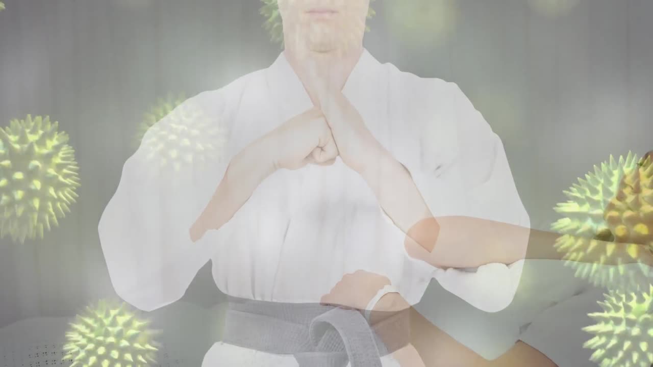 카라테 의상을 입은 백인 여성의 중간 부분에 바이러스 세포의 애니메이션