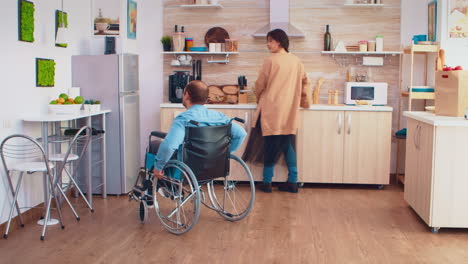 un hombre discapacitado en silla de ruedas abre el refrigerador