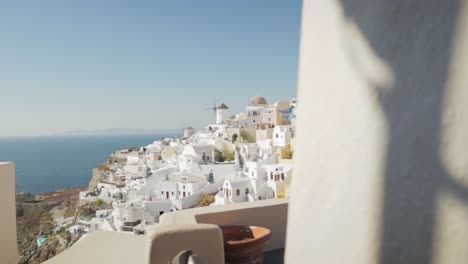 Weite-Pfannenoffenbarung-Weißer-Traditioneller-Windmühlen-Und-Griechischer-Flagge-In-Santorini,-Griechenland