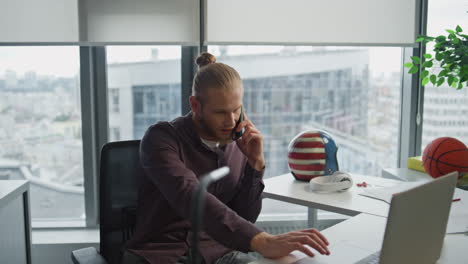 Lächelnder-Geschäftsmann-Telefoniert-Im-Büro,-Nahaufnahme.-Mann-Schaut-Laptop-An