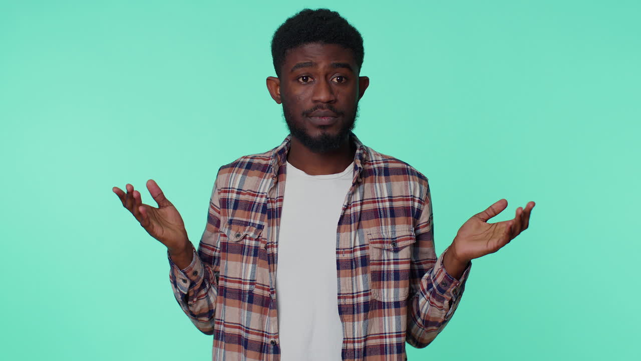 Clueless african american man raising hands in helpless gesture, confused by difficult question